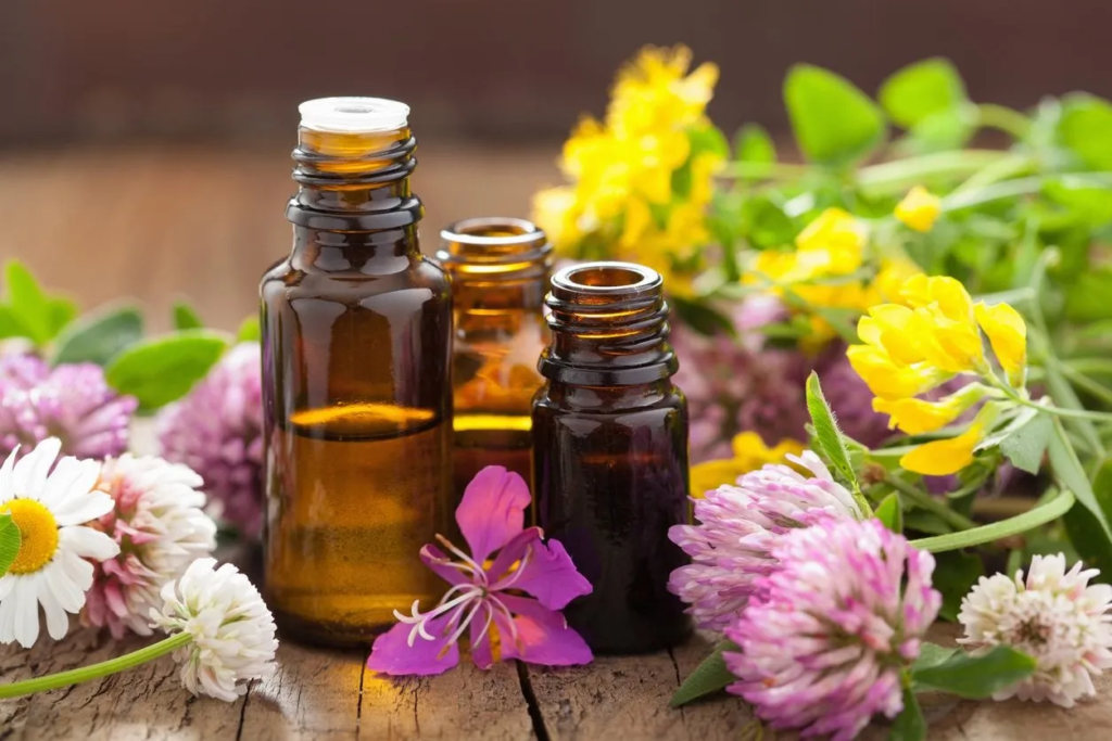 Three aromatherapy bottles surrounded by flowers